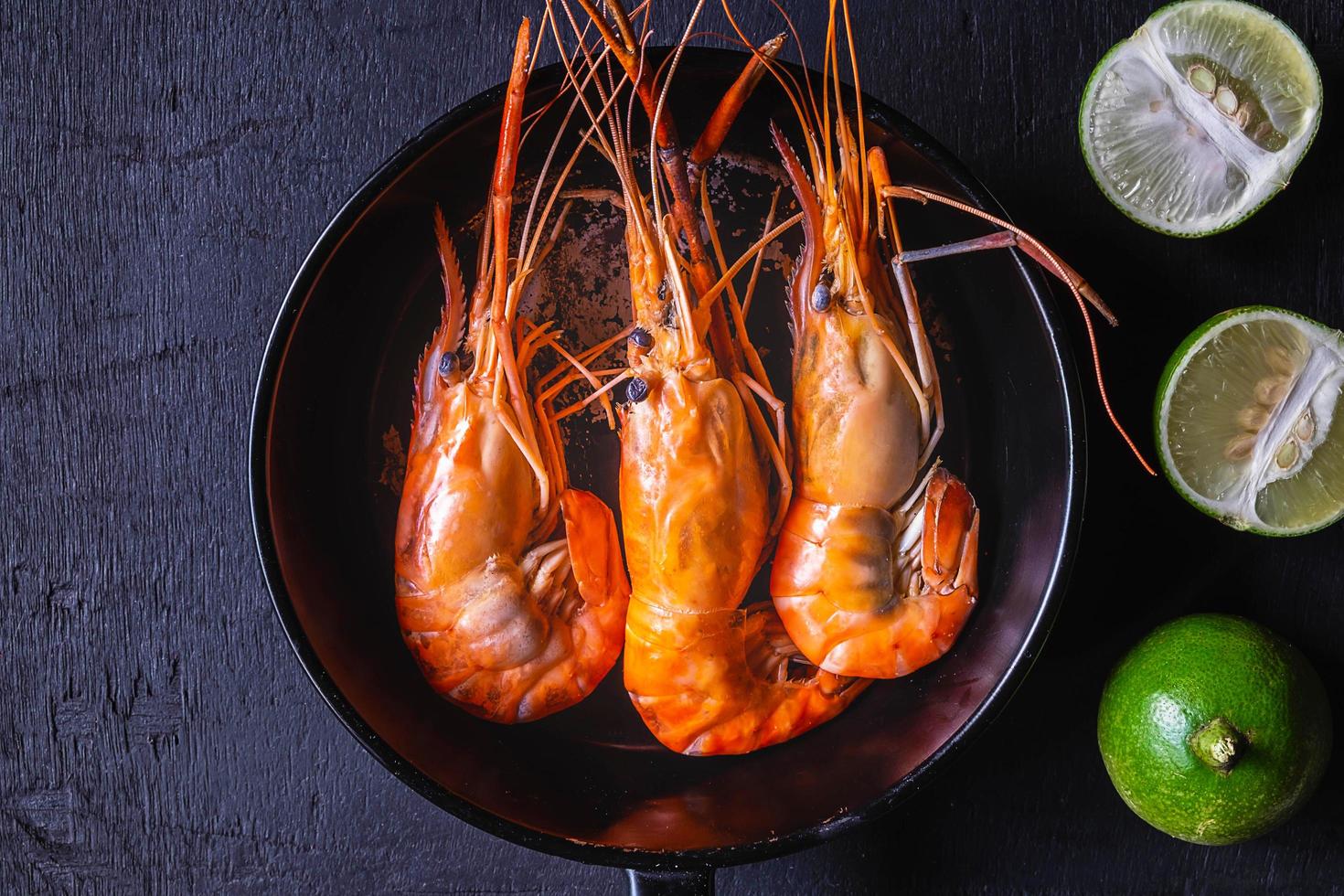 camarones en una sartén sobre un fondo oscuro foto