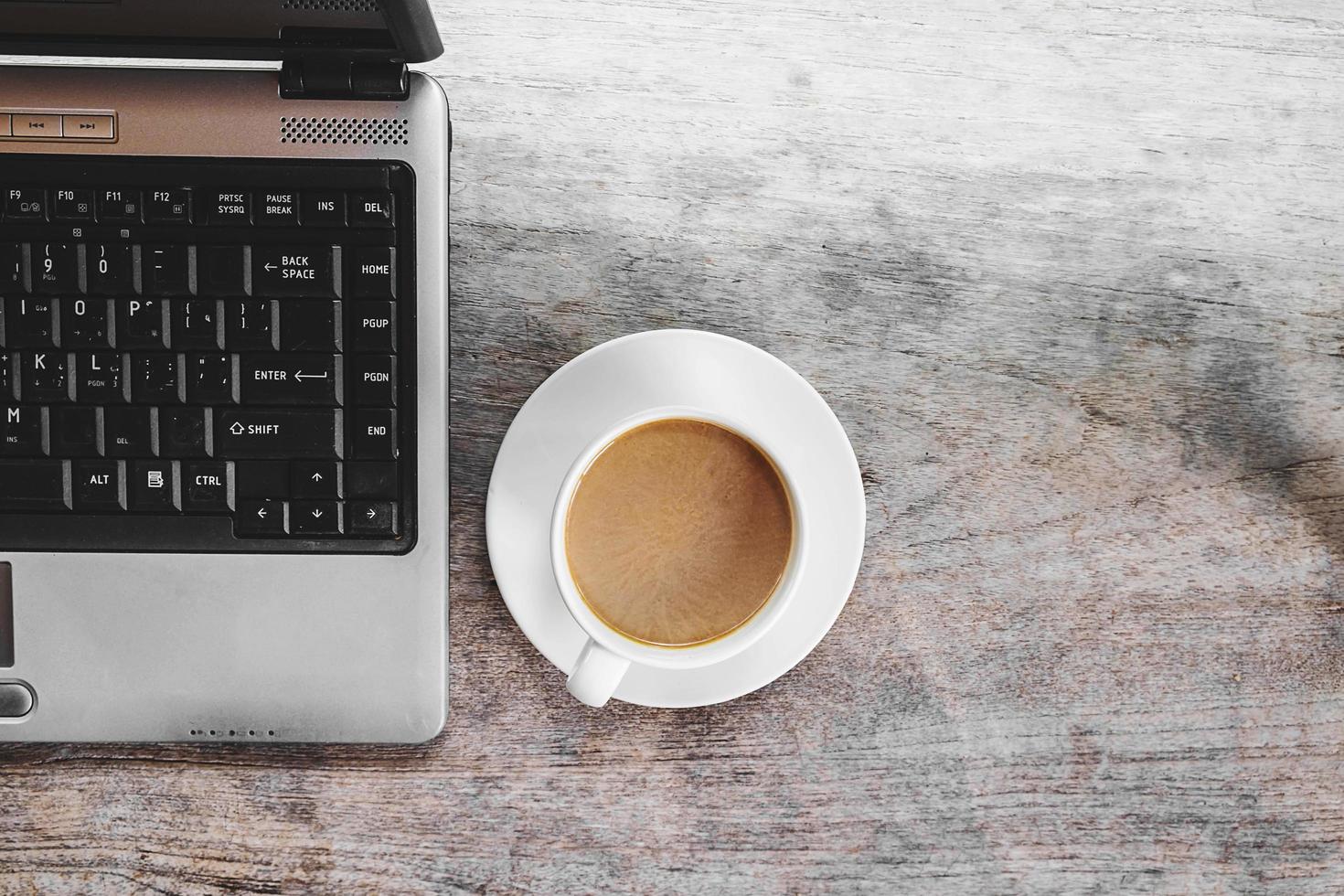 Coffee cup and laptop on a desk photo