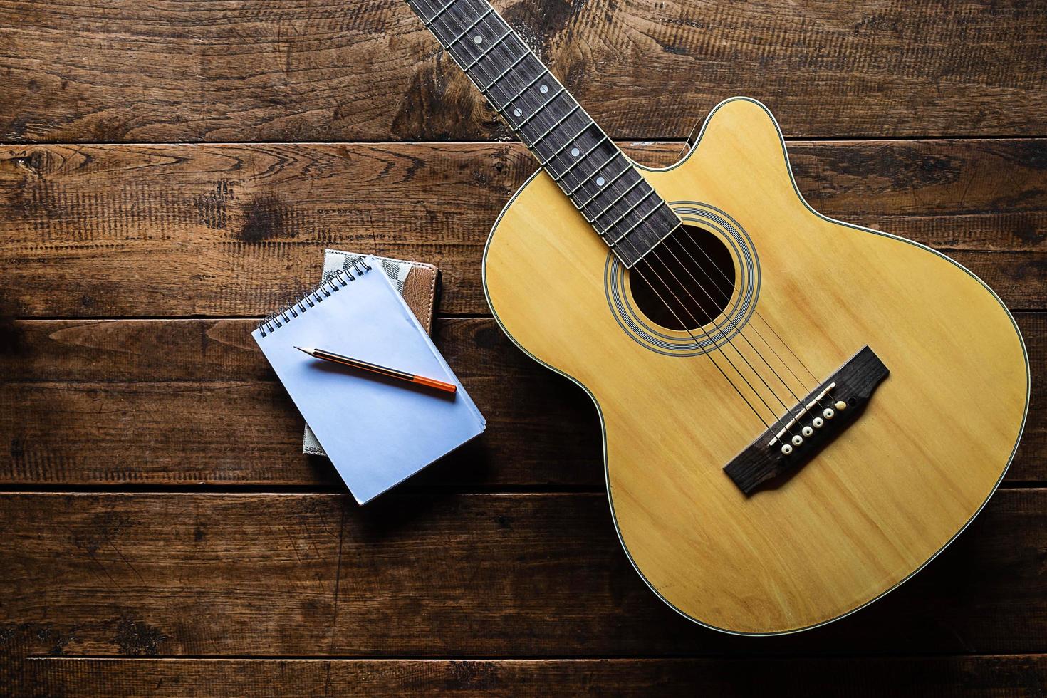 vista superior de una guitarra y un bloc de notas foto
