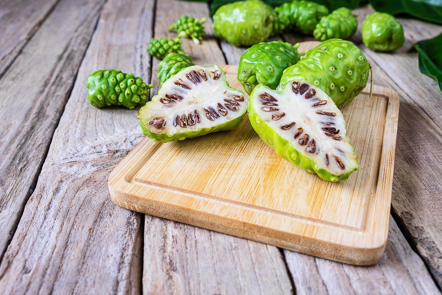 fruta de noni en una tabla de cortar foto