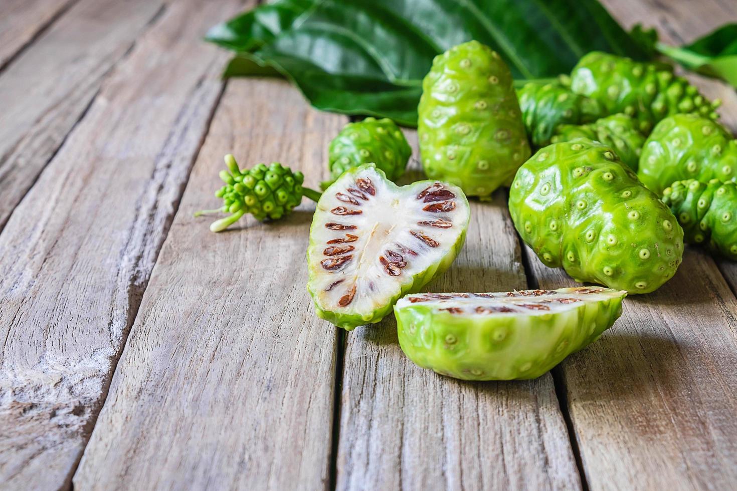 Noni fruit on a wooden background photo