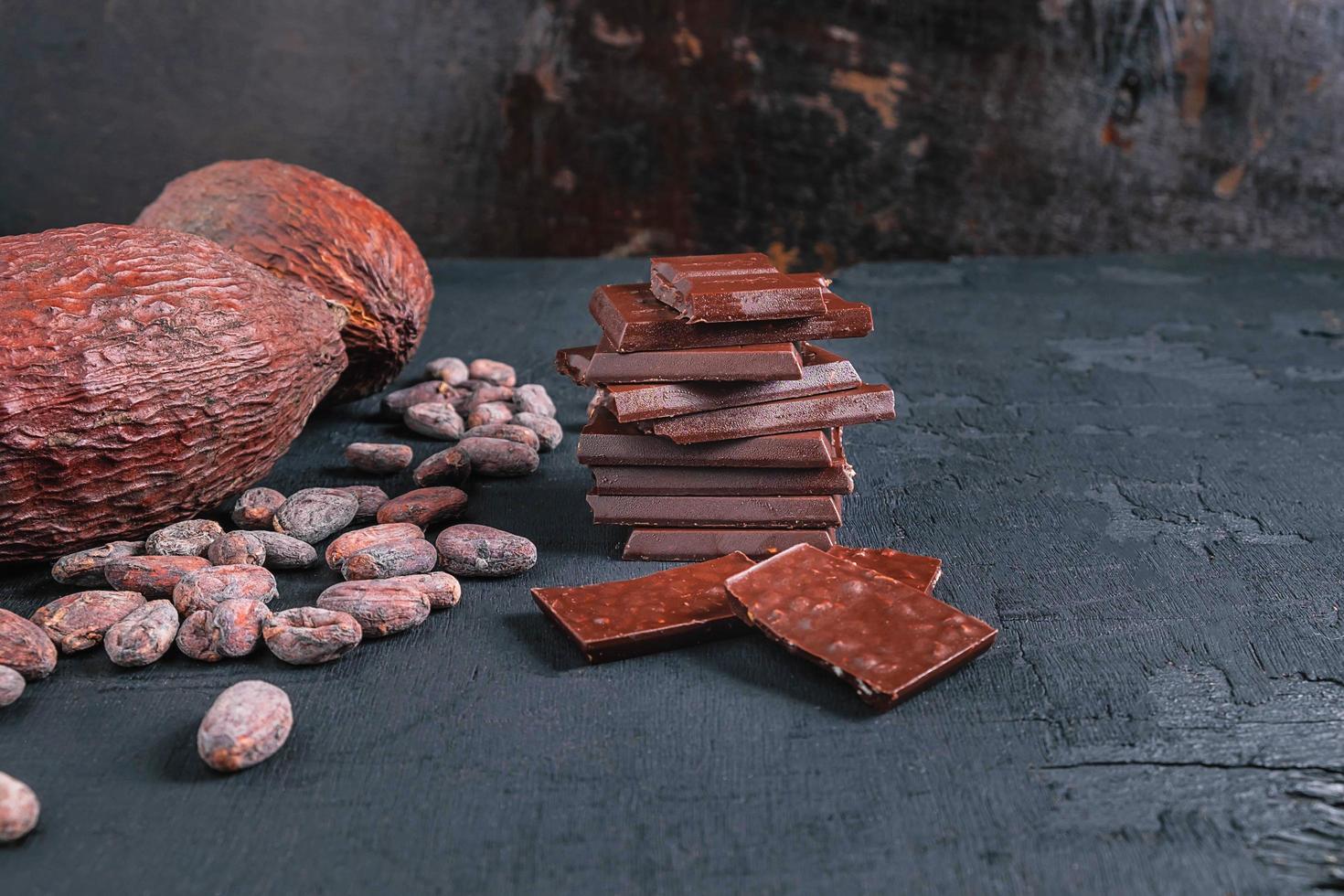 granos de chocolate y cacao sobre fondo oscuro foto
