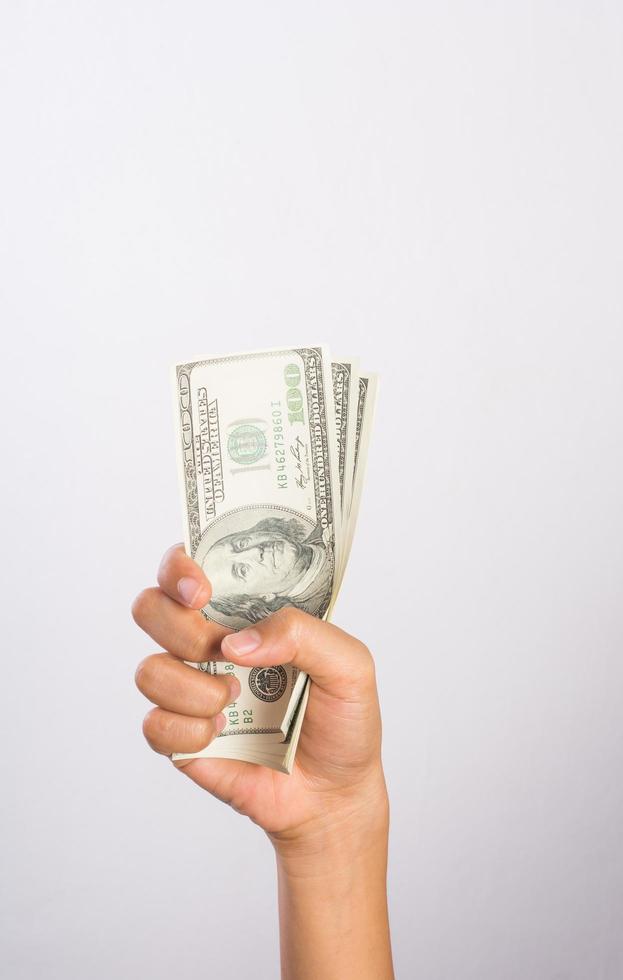 Mano de mujer con dinero aislado sobre fondo blanco. foto