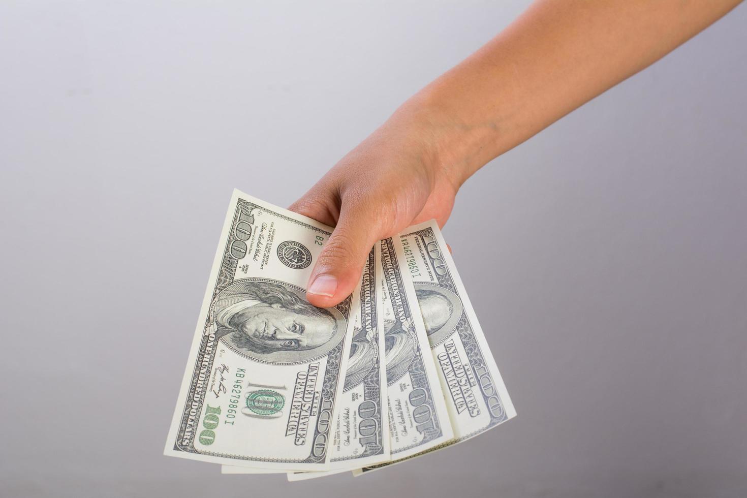 Mano de mujer con dinero aislado sobre fondo blanco. foto