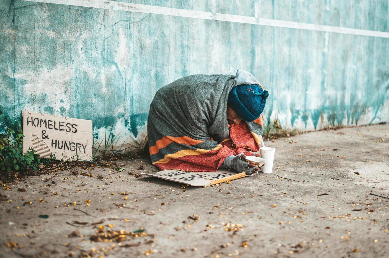 mendigos sentados en la calle con mensajes para personas sin hogar por favor ayuda foto