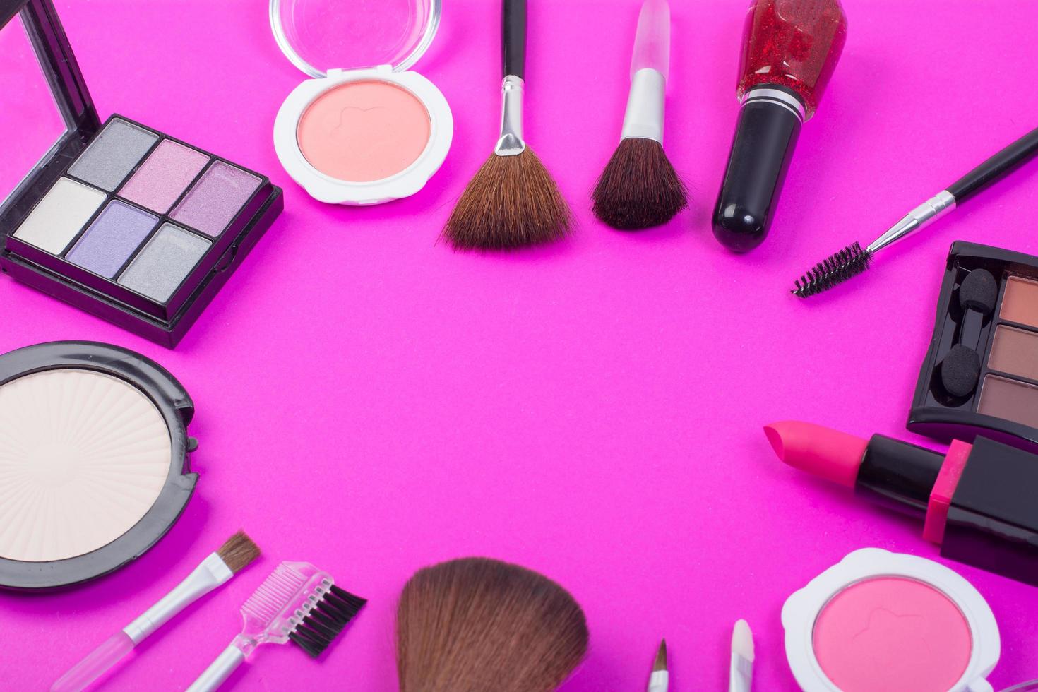 Vista superior de una colección de productos cosméticos de belleza sobre un fondo rosa foto