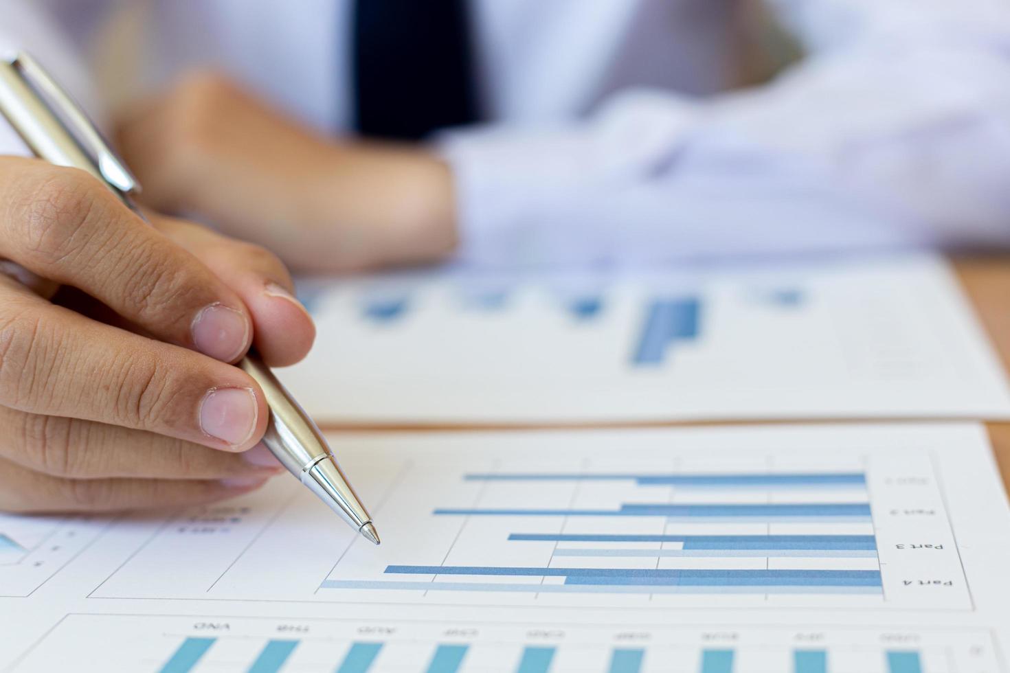 Using pen to mark up business charts photo