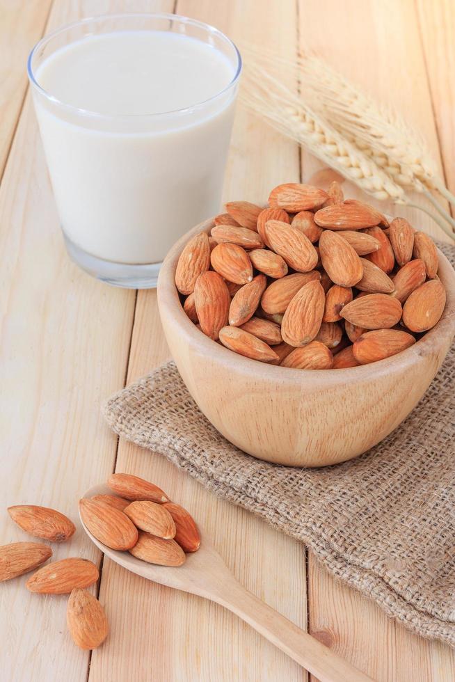 Almond milk with almonds on wooden table photo