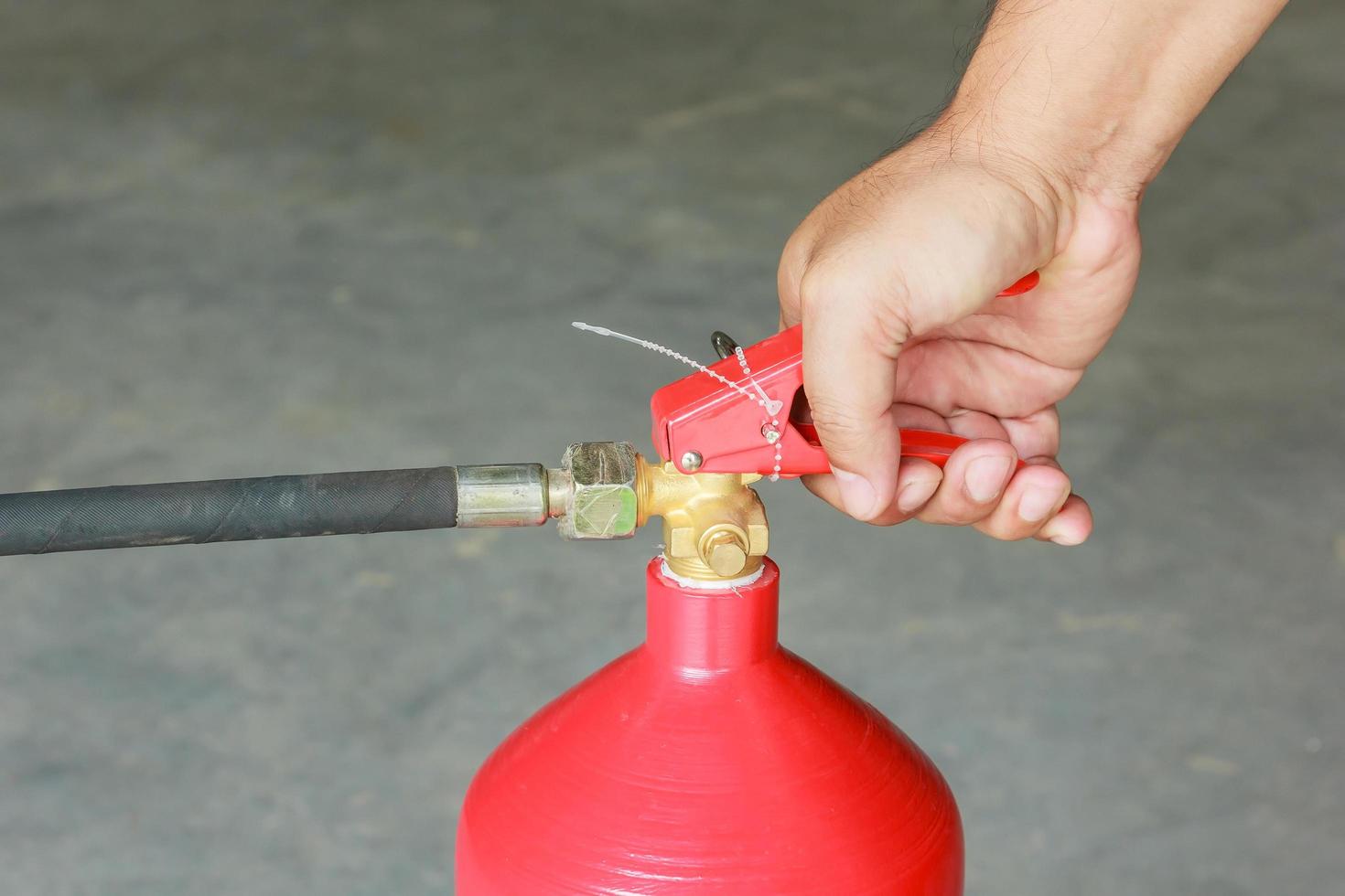 Hand pressing the trigger of fire extinguisher photo