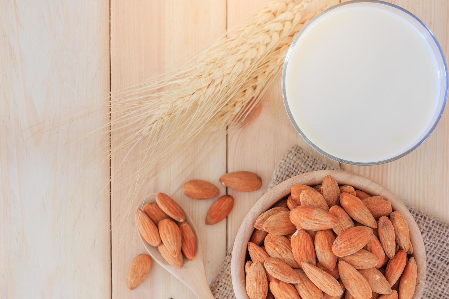 Almond milk in glass with almonds on the table photo