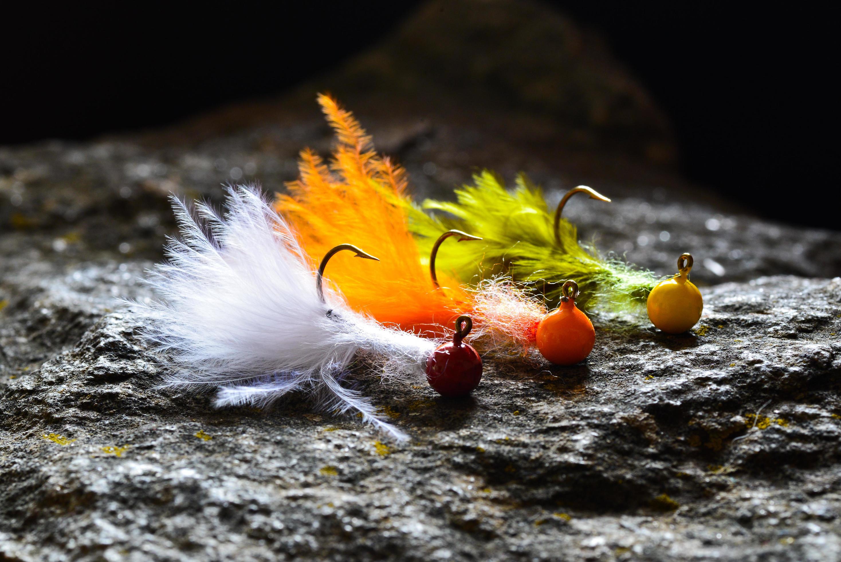 Group of colorful jig streamers made of feathers on gray stone 1987153 Stock Photo at Vecteezy