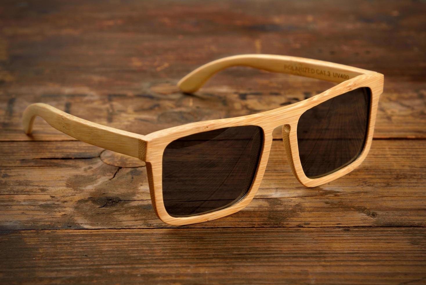 Bright wooden sunglasses on wooden surface photo