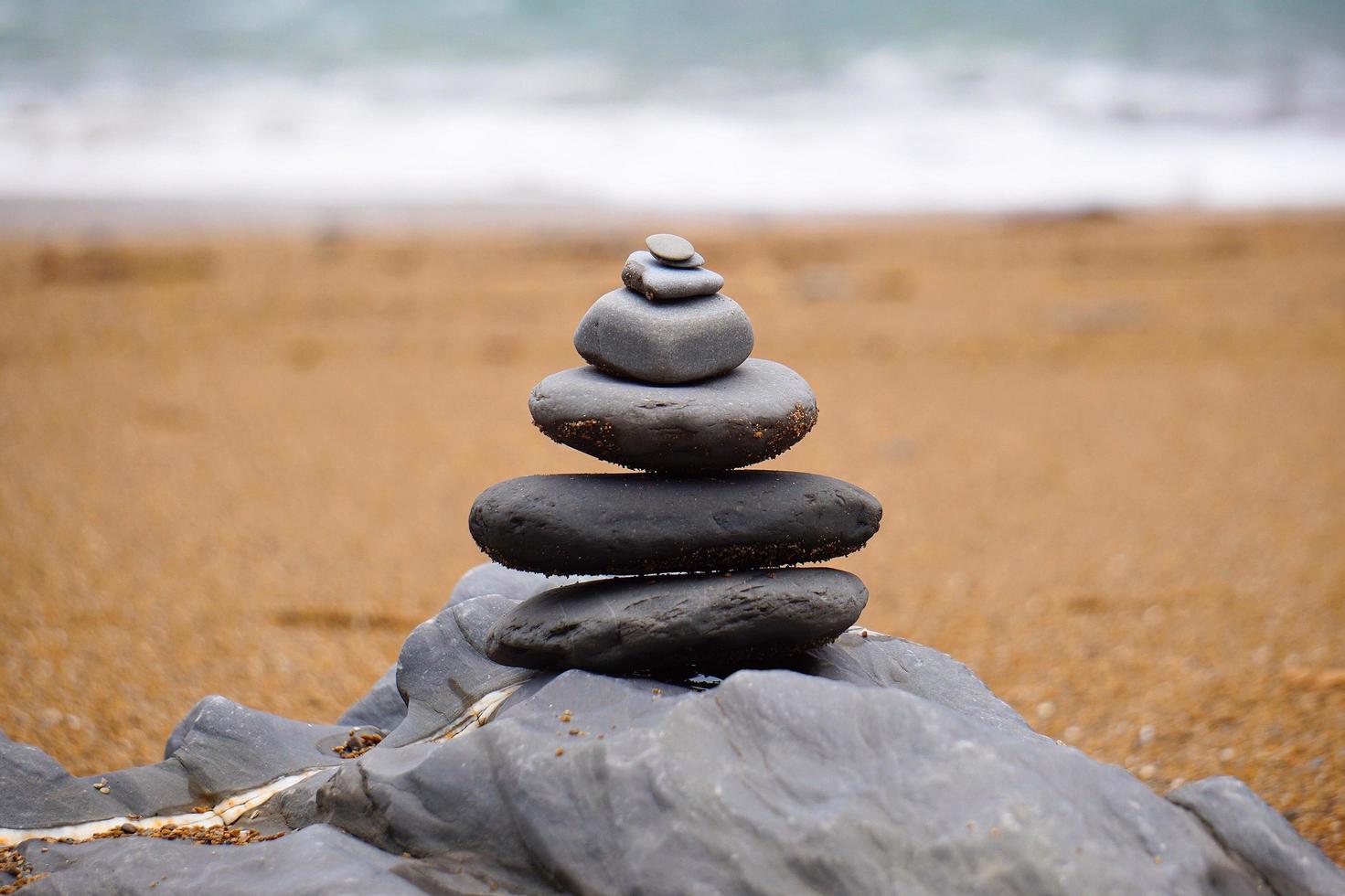 equilibrio de piedra en la playa foto