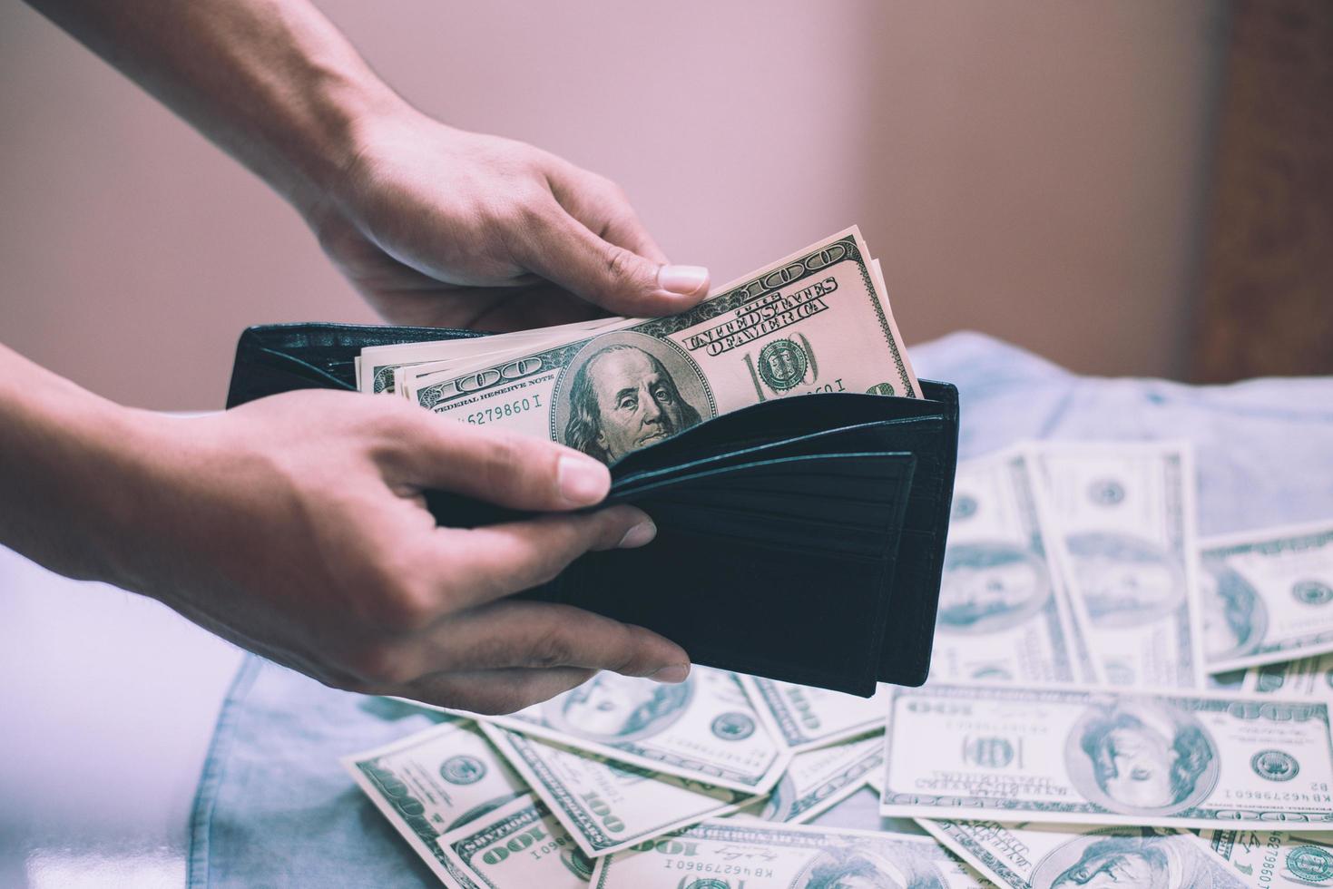 A man counting cash with money in the wallet photo