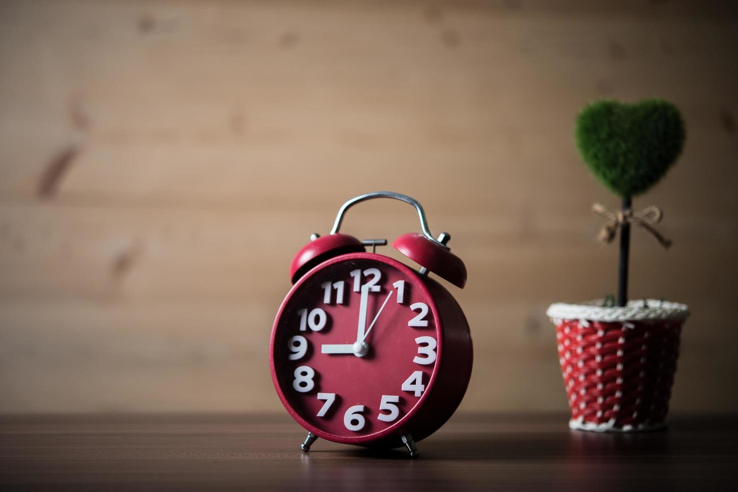 Tree of heart with red alarm clock on wooden table photo