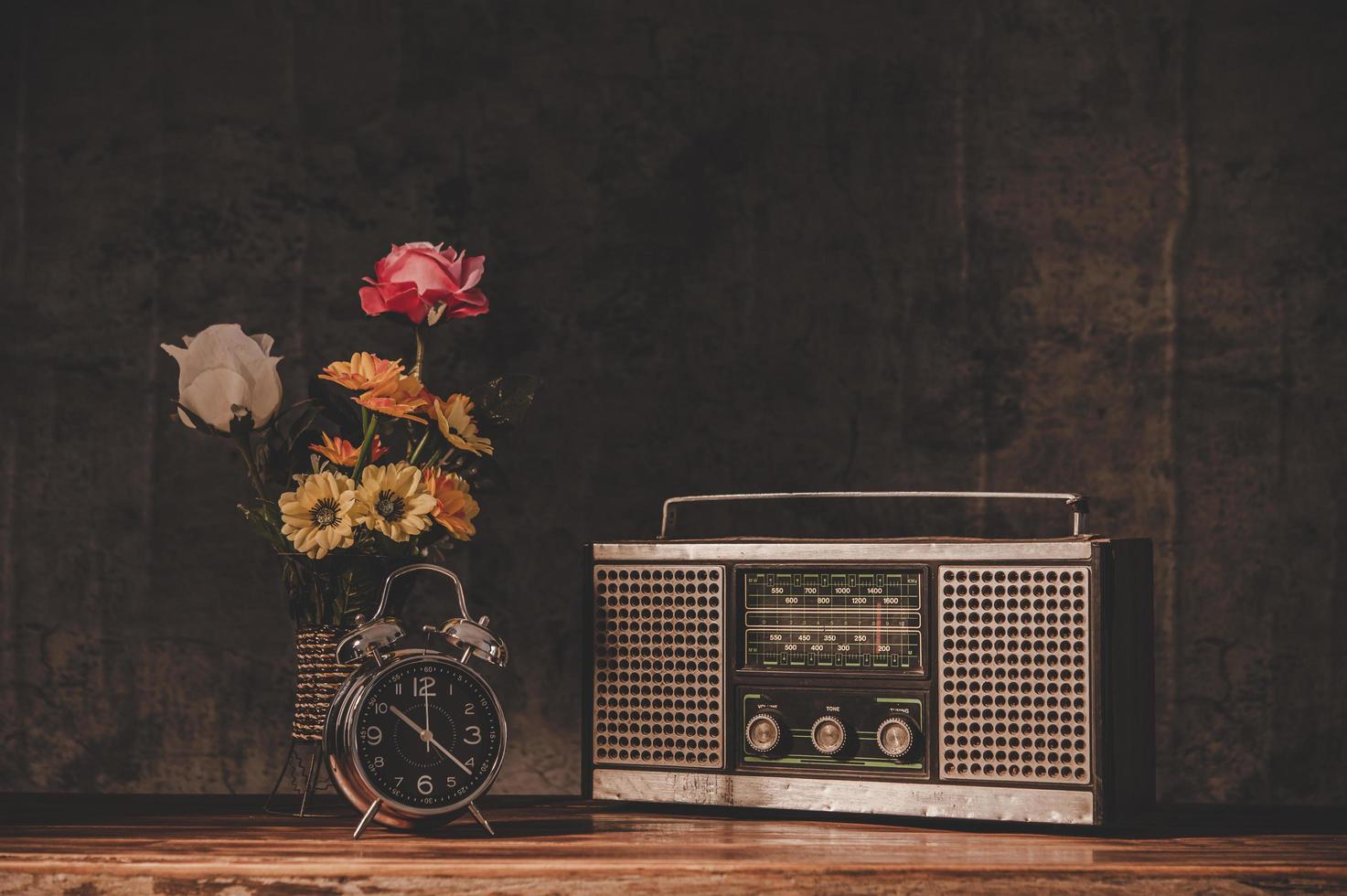 Receptor de radio retro bodegón con relojes y floreros foto