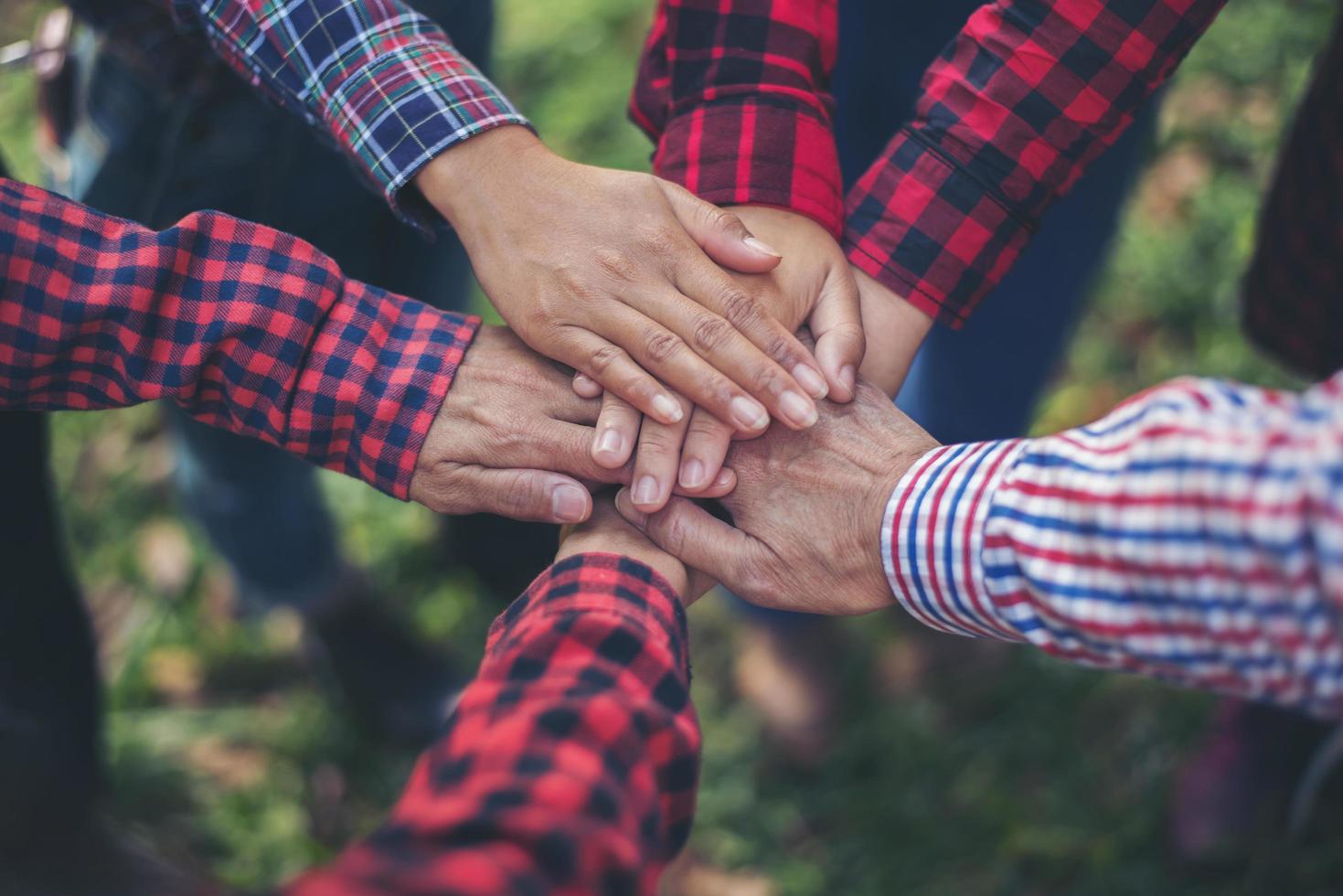 Close-up view of young people putting their hands together photo