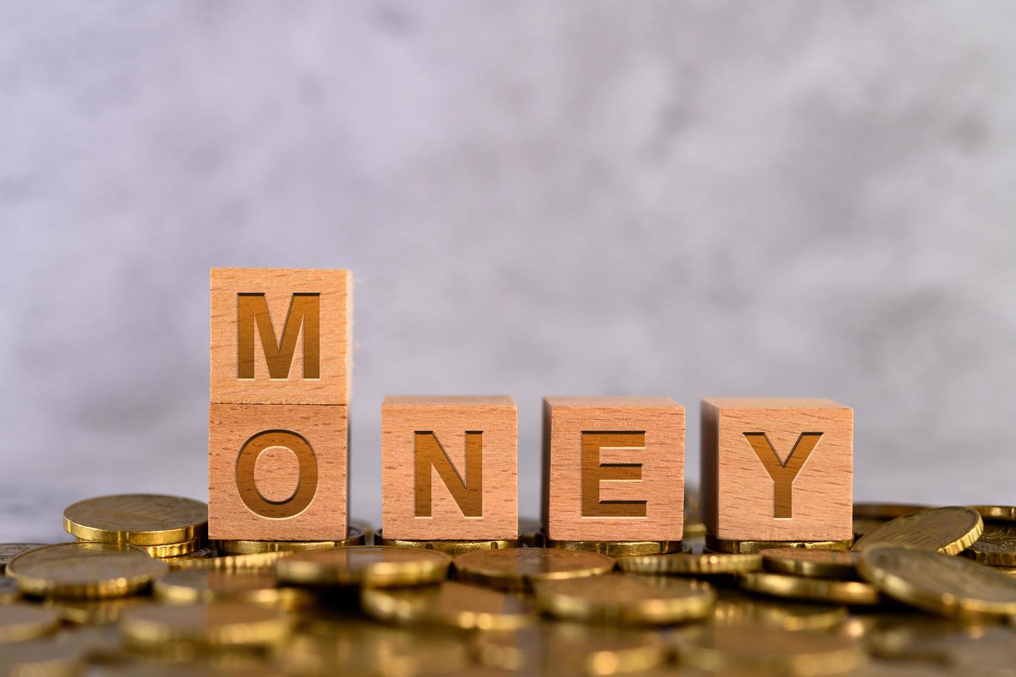 Alphabet wooden cube letters MONEY on gold coins photo