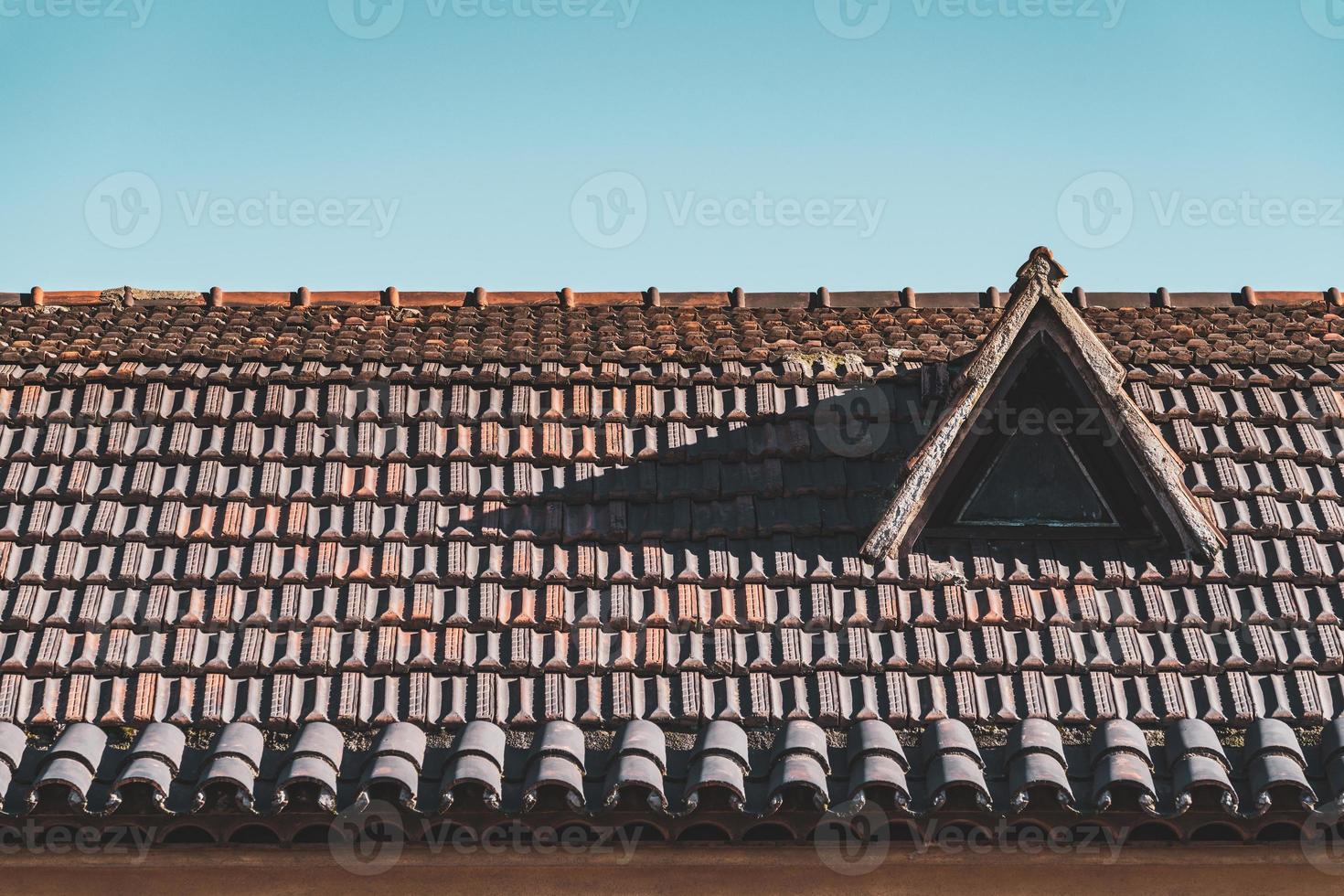 Buhardilla en un techo de tejas de terracota foto