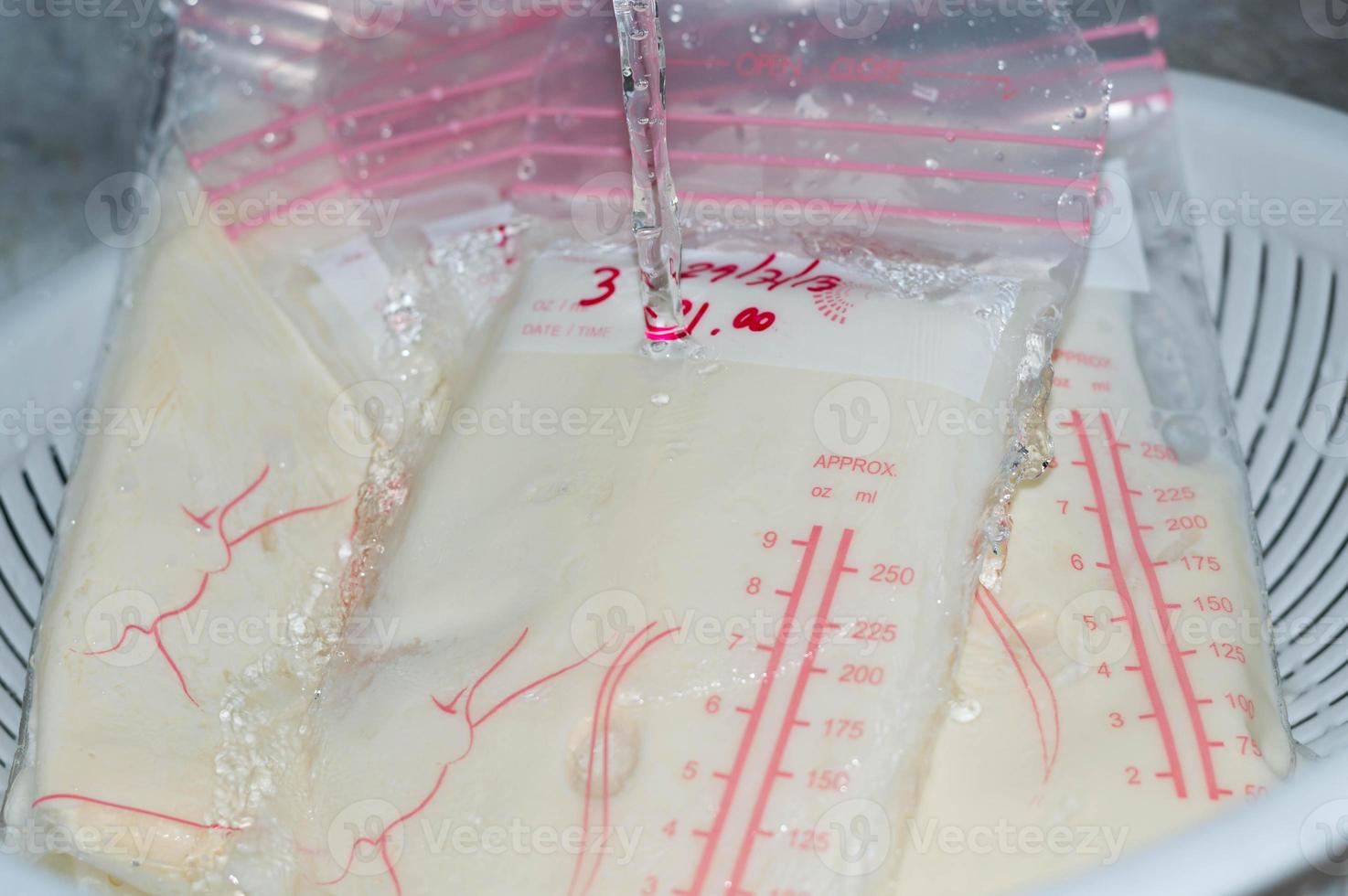 Defrosting frozen breastmilk with water photo