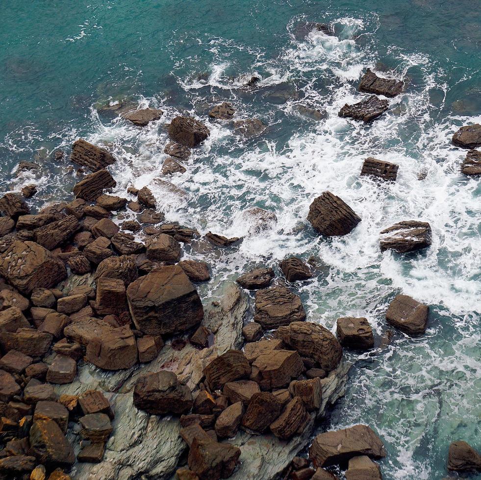 Olas golpeando rocas en la costa de Bilbao, España foto