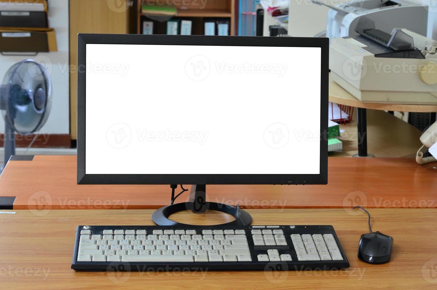 Escritorio de ordenador antiguo con pantalla en blanco en la sala de oficina foto