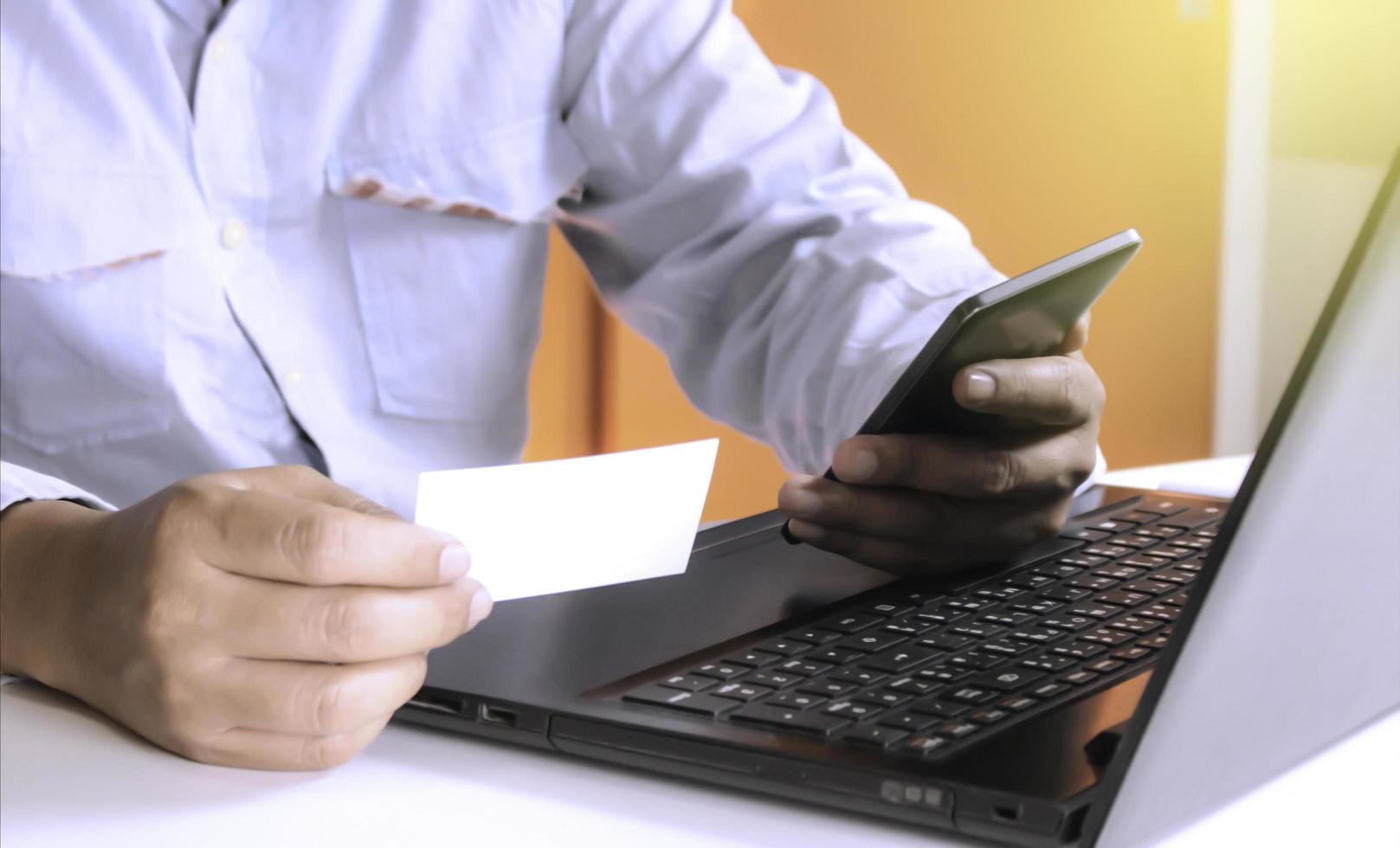 Person holding a phone and a business card photo