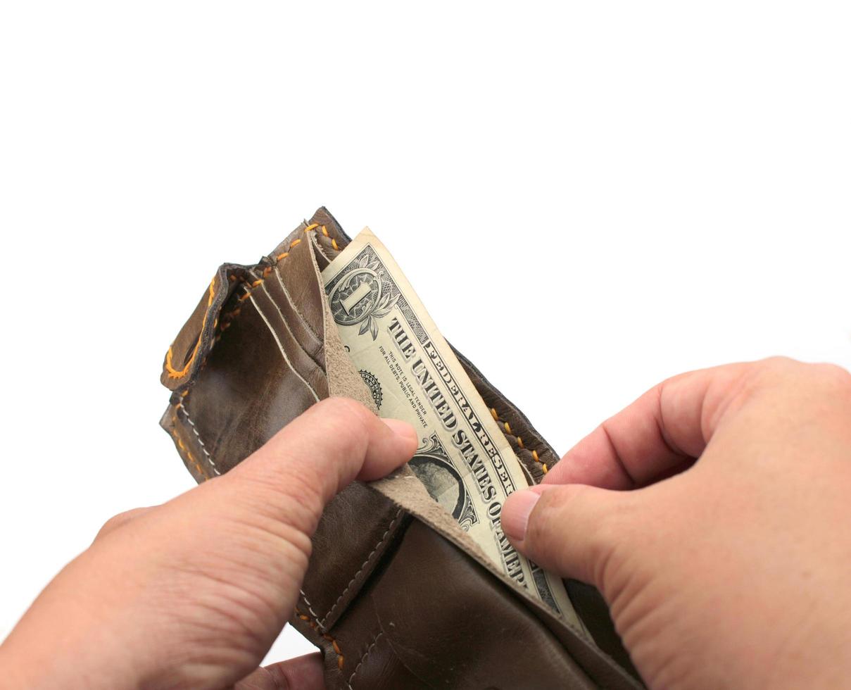 Person pulling out money from a wallet photo