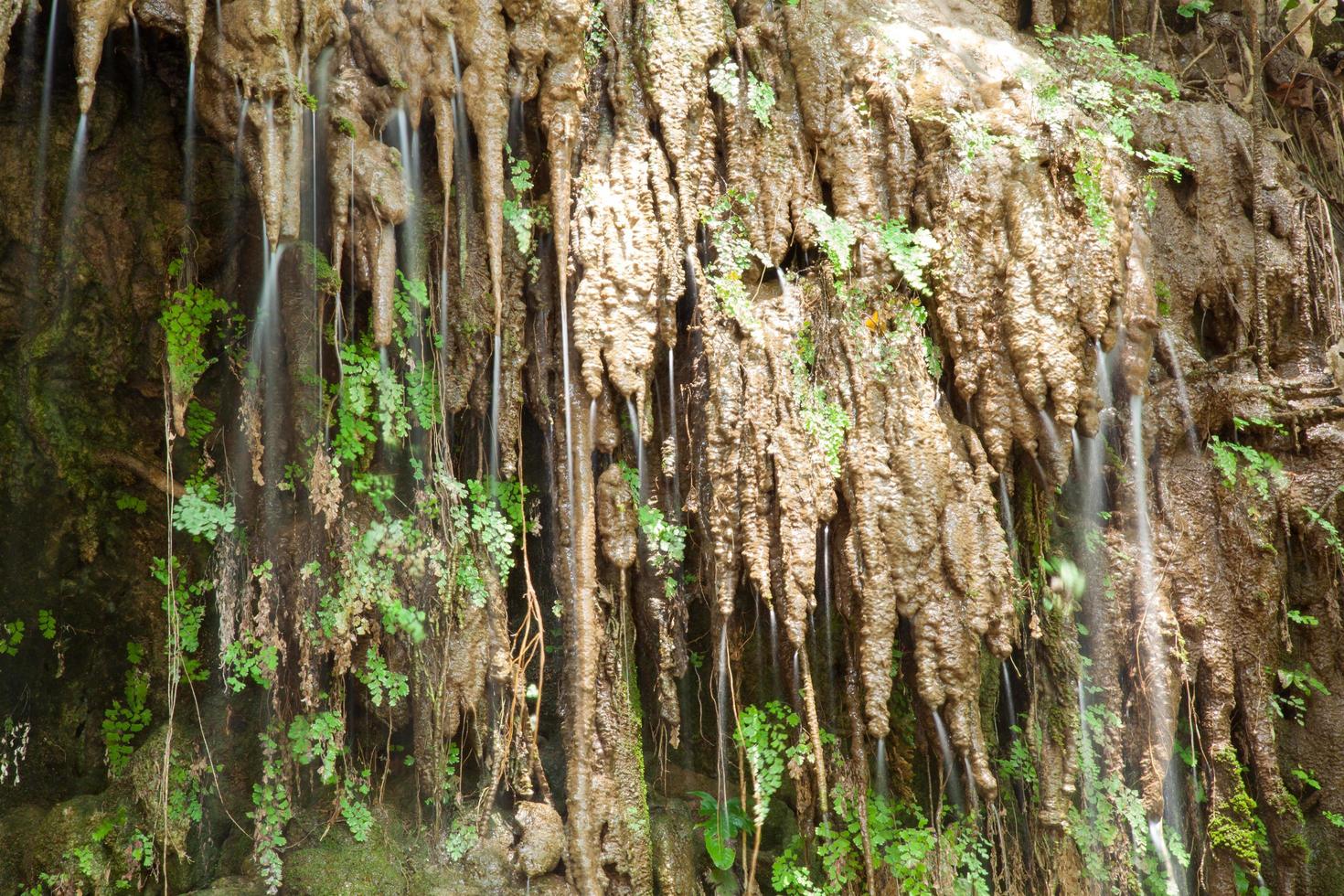 Water flowing down on the rock wall photo