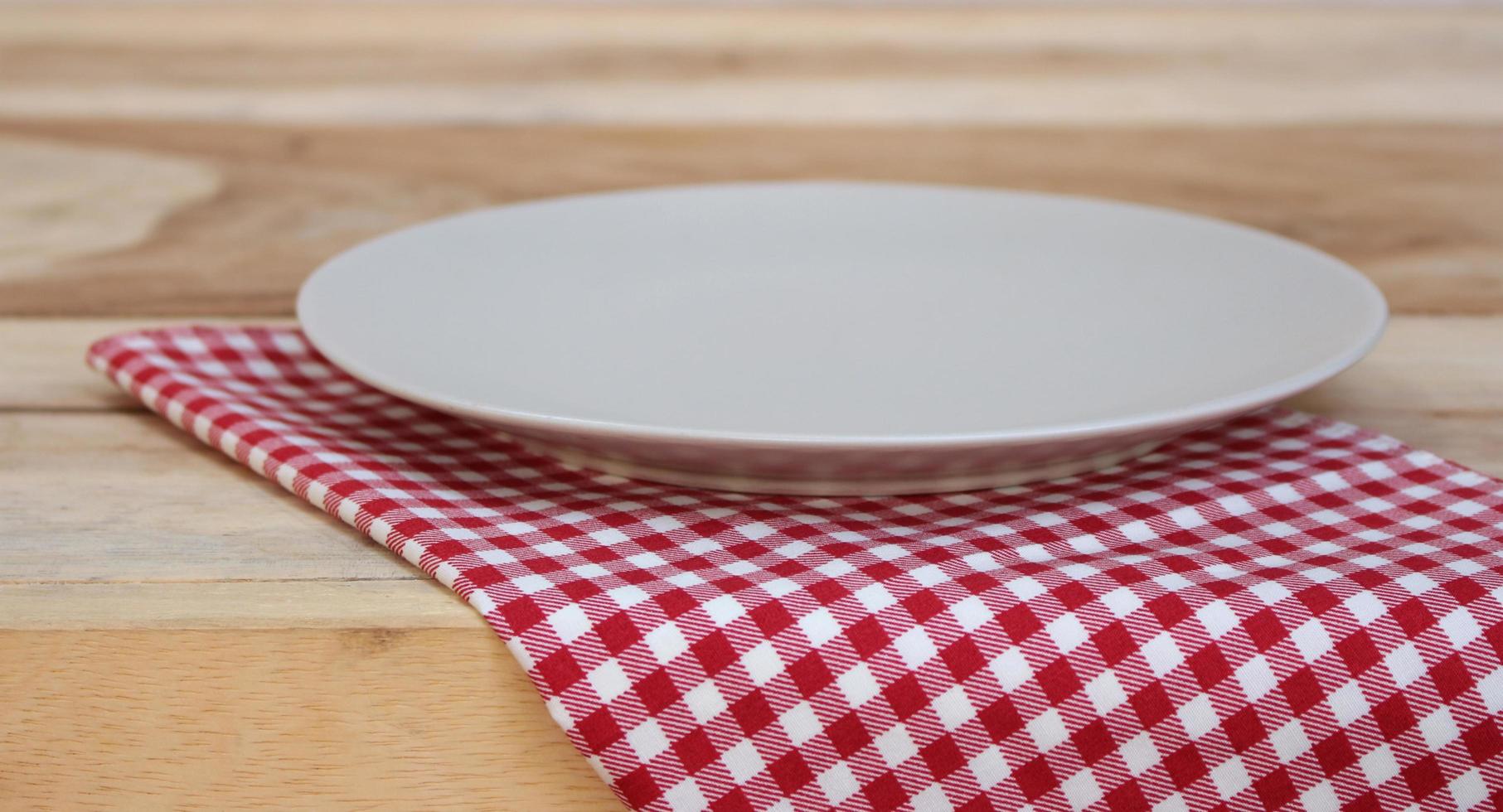 Plate on checkered tablecloth on a table photo