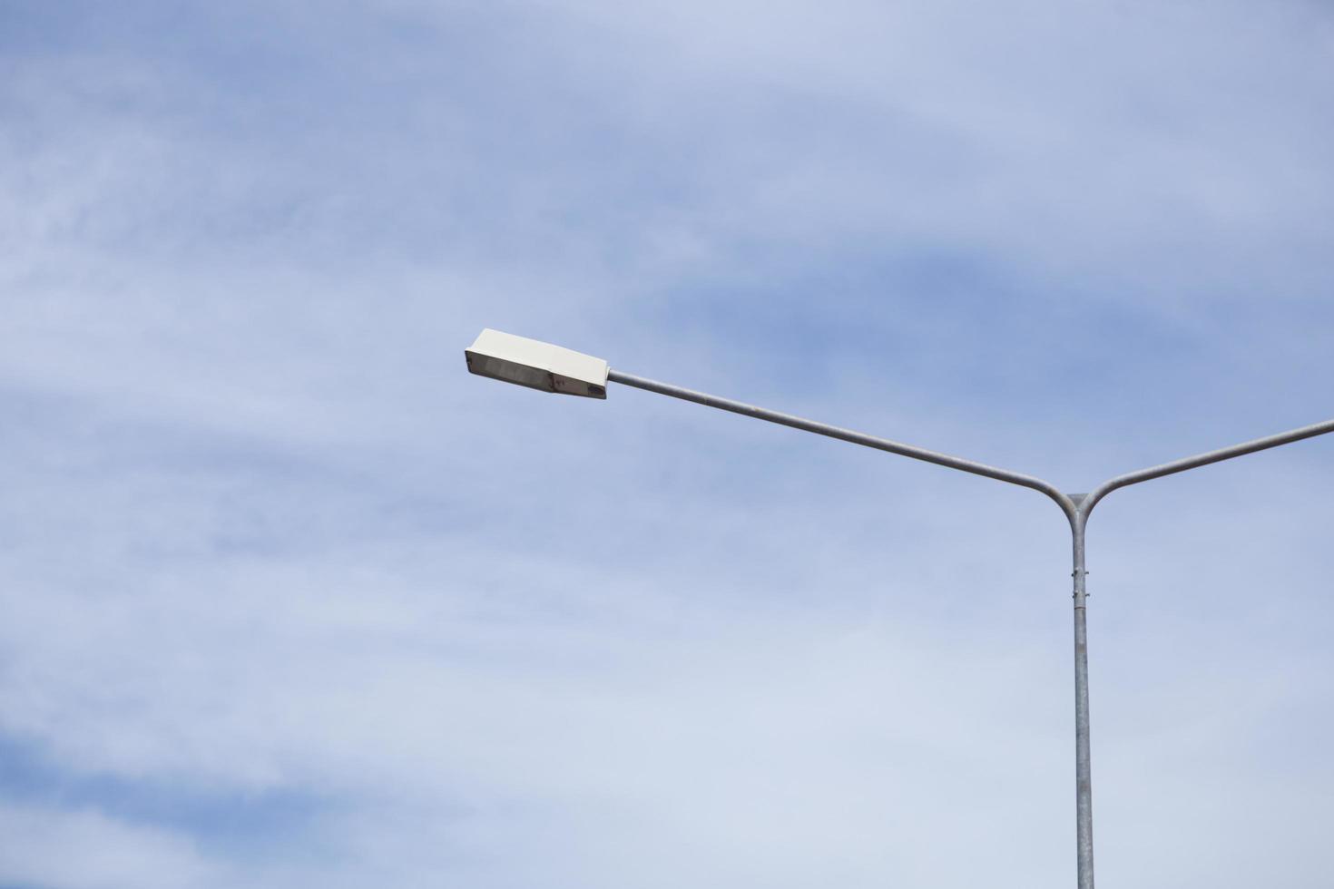 poste de luz bajo el cielo azul foto