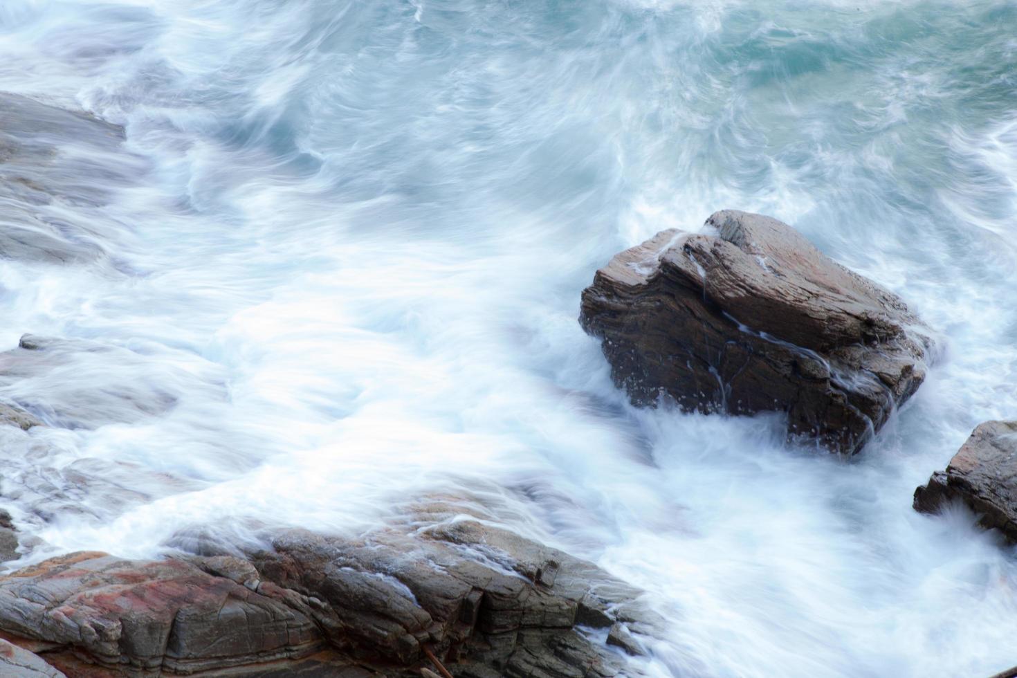 olas del océano chocando contra las rocas foto