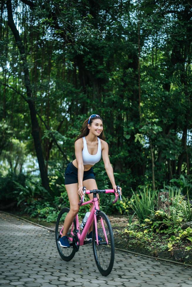 mujer joven, andar en bicicleta, en el parque foto