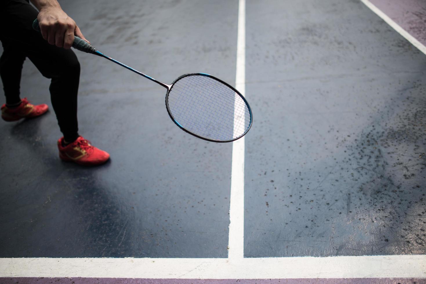 Young man playing badminton outdoors photo