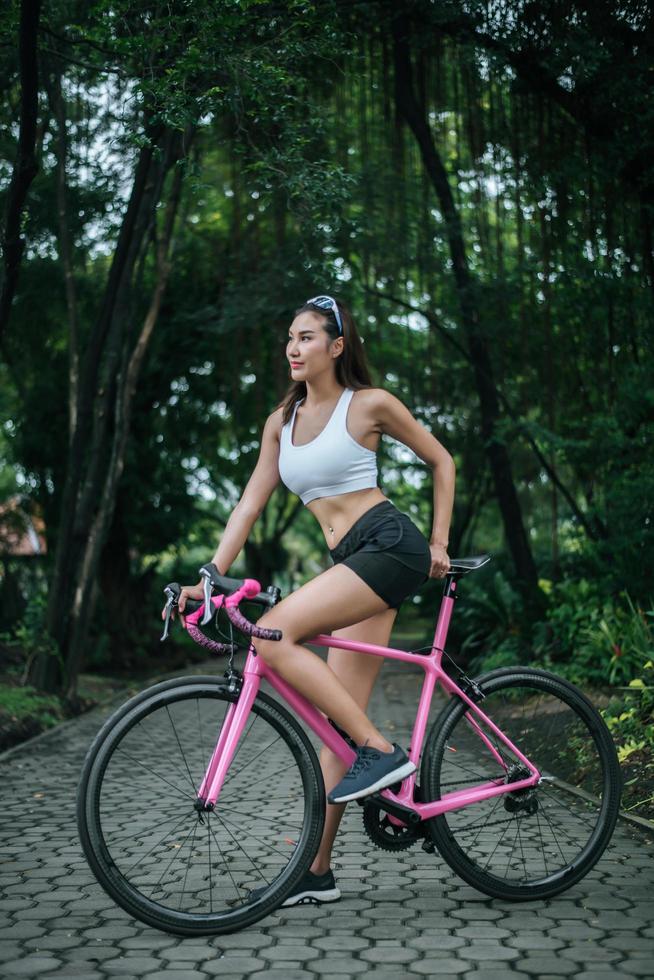 mujer montando una bicicleta rosa foto