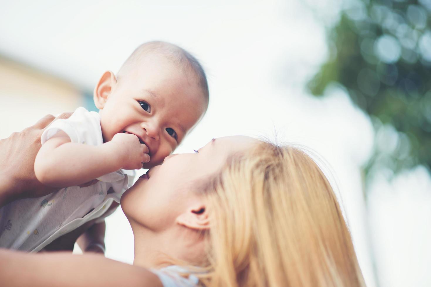 Mother and baby laughing and playing at the park photo