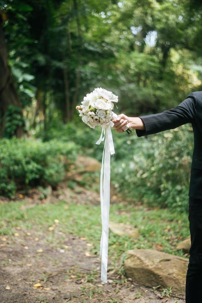 Cerca del novio con un hermoso ramo en las manos de la novia foto
