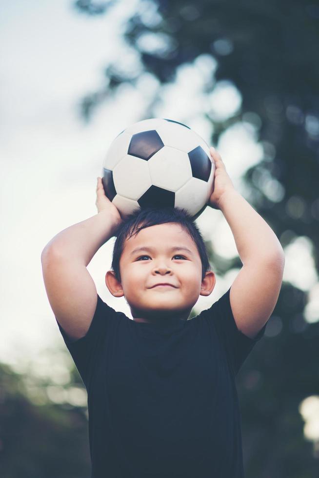 Little boy playing soccer football photo