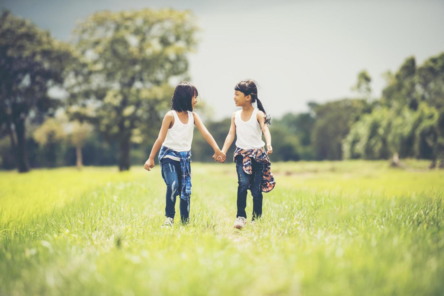 dos niñas cogidas de la mano en el parque foto