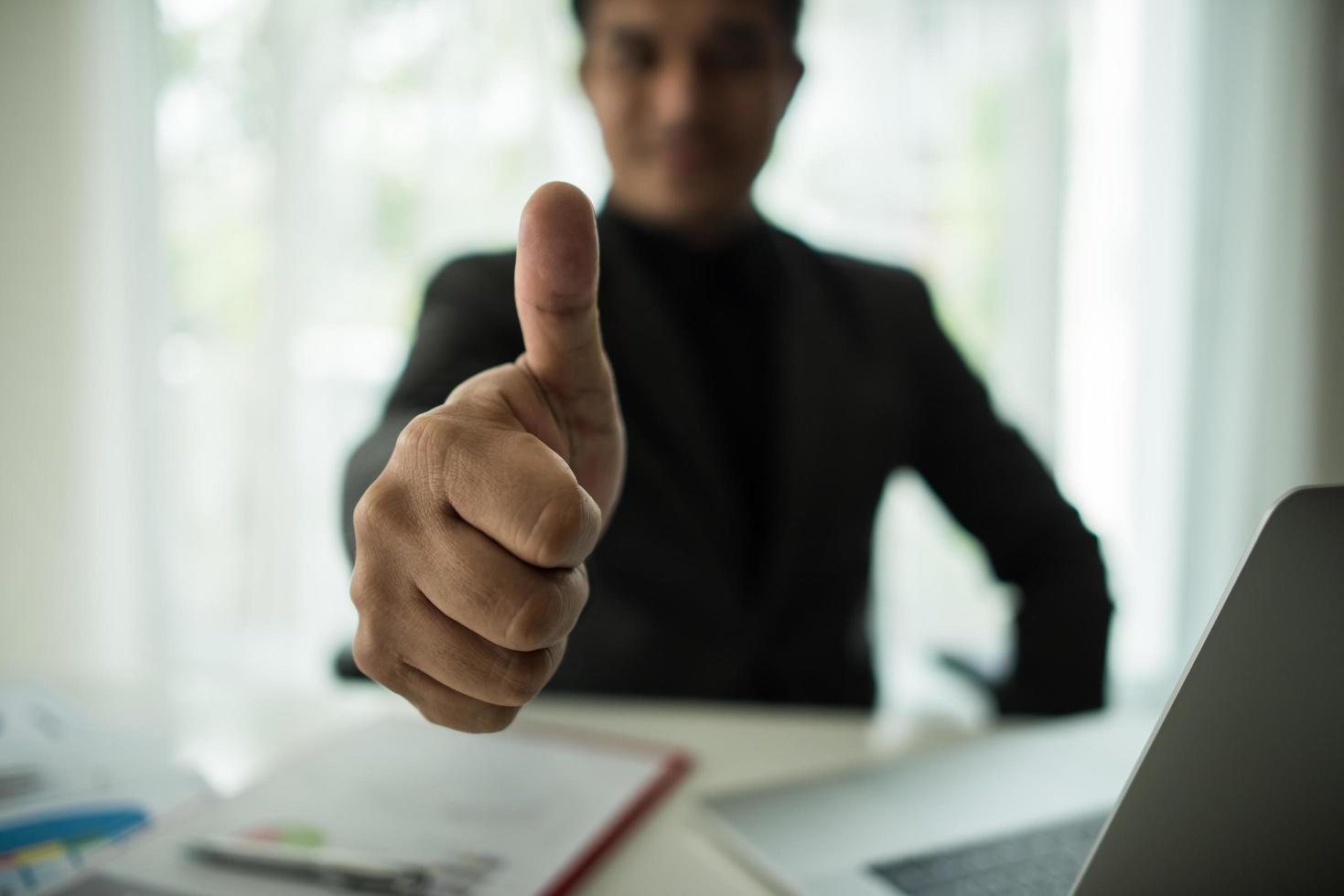 hombre de negocios da un pulgar hacia arriba foto