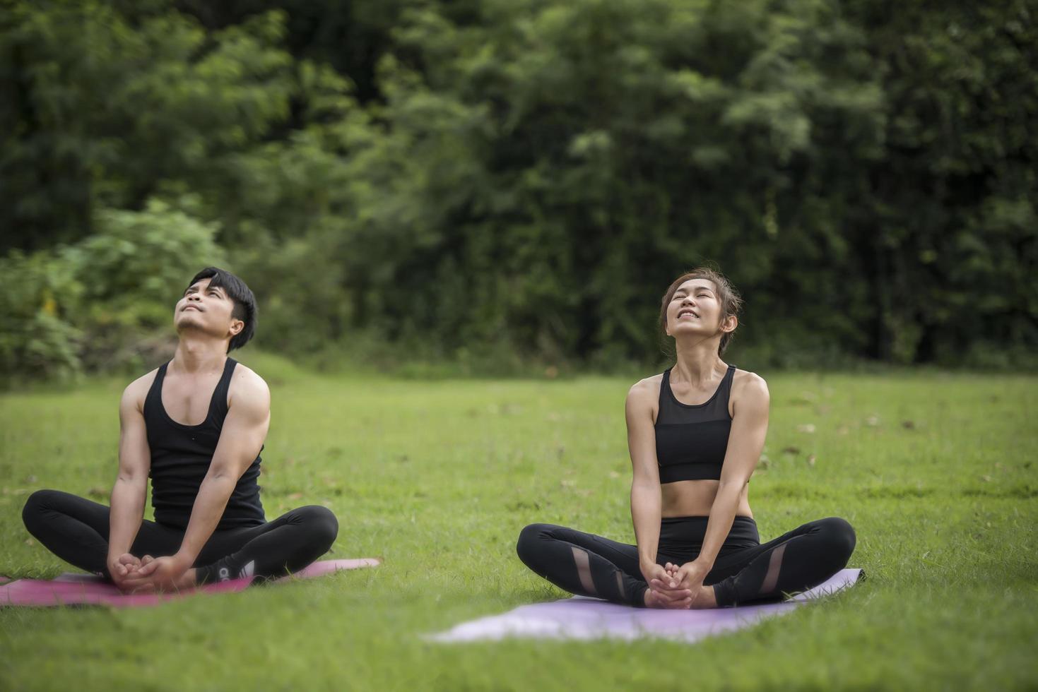 pareja haciendo yoga en el parque foto