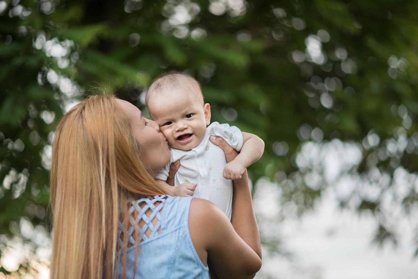 Mother and baby laughing and playing at the park photo