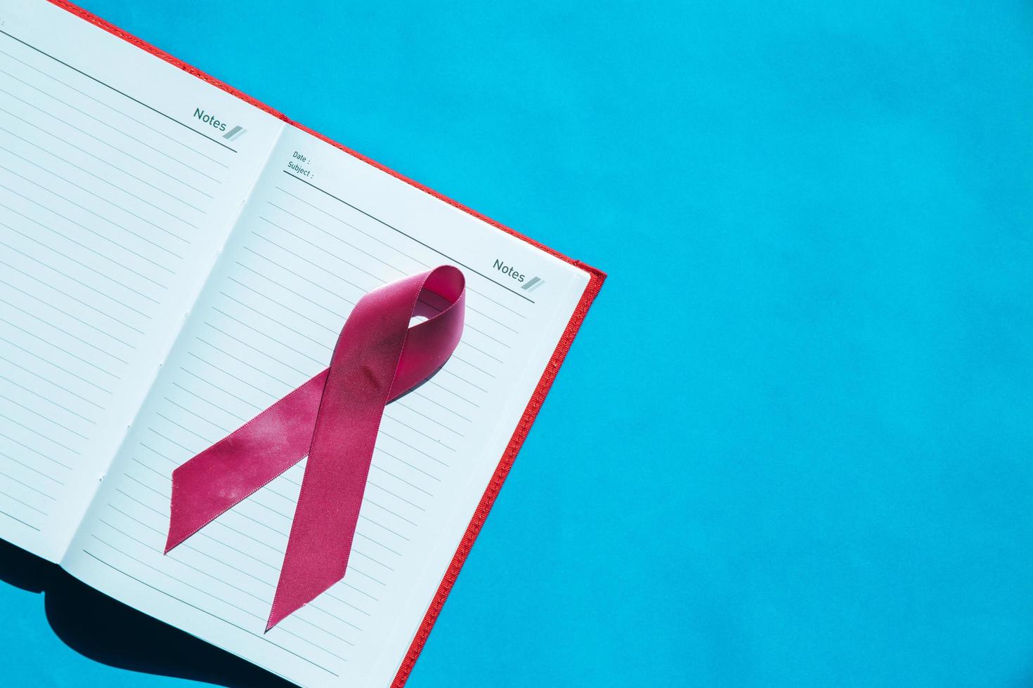 Ribbon cancer sign on notebook photo