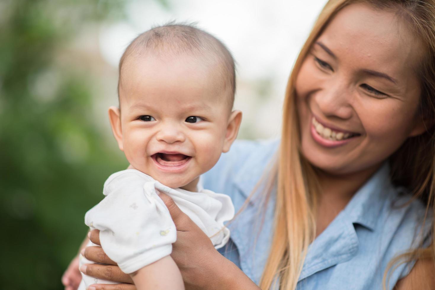 Mother and baby laughing and playing at the park photo