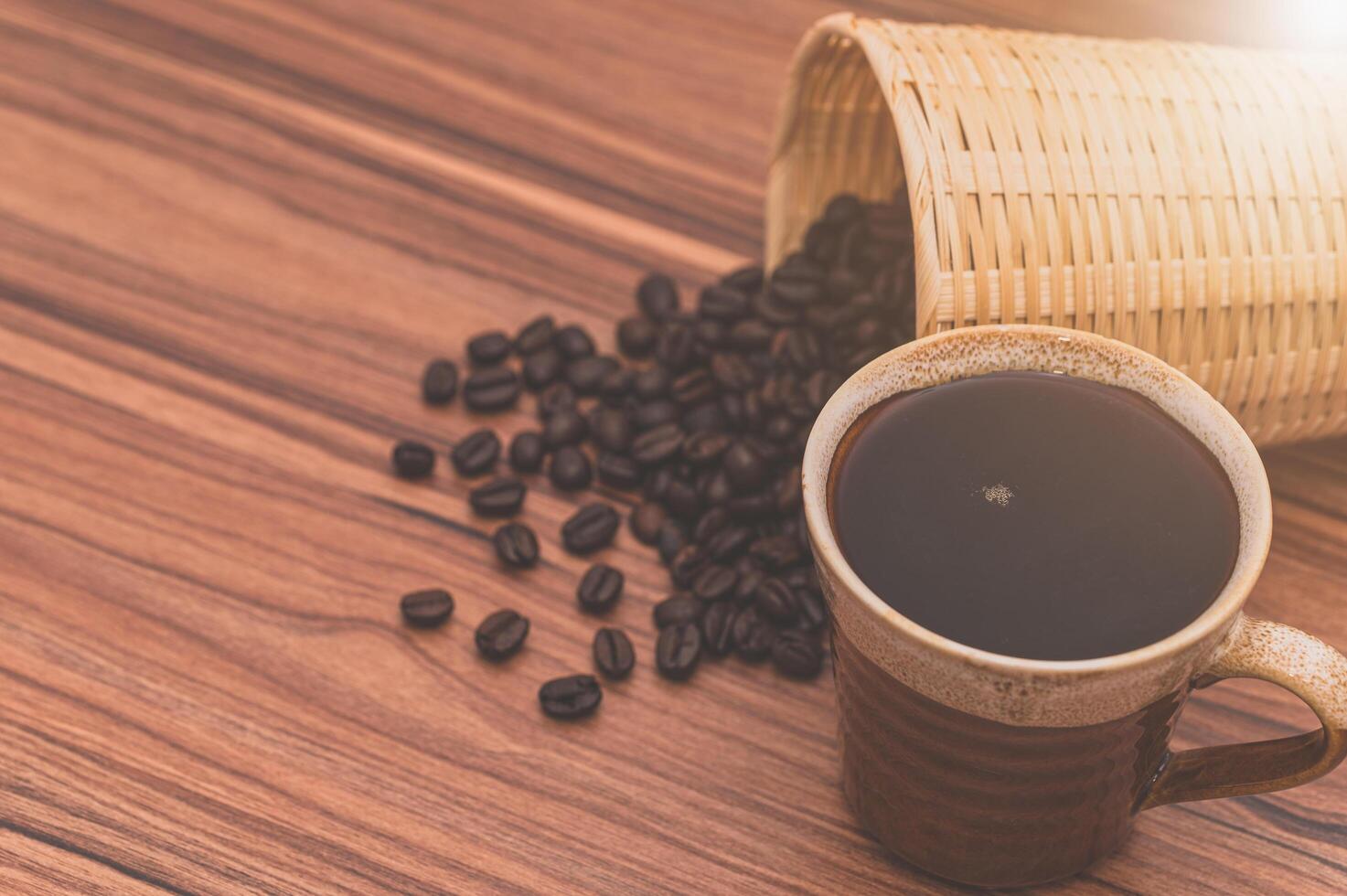 granos de café y taza de café en la mesa foto