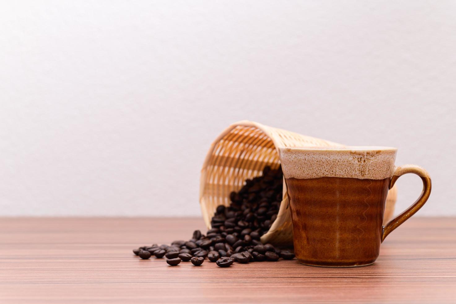 granos de café y taza de café en la mesa foto