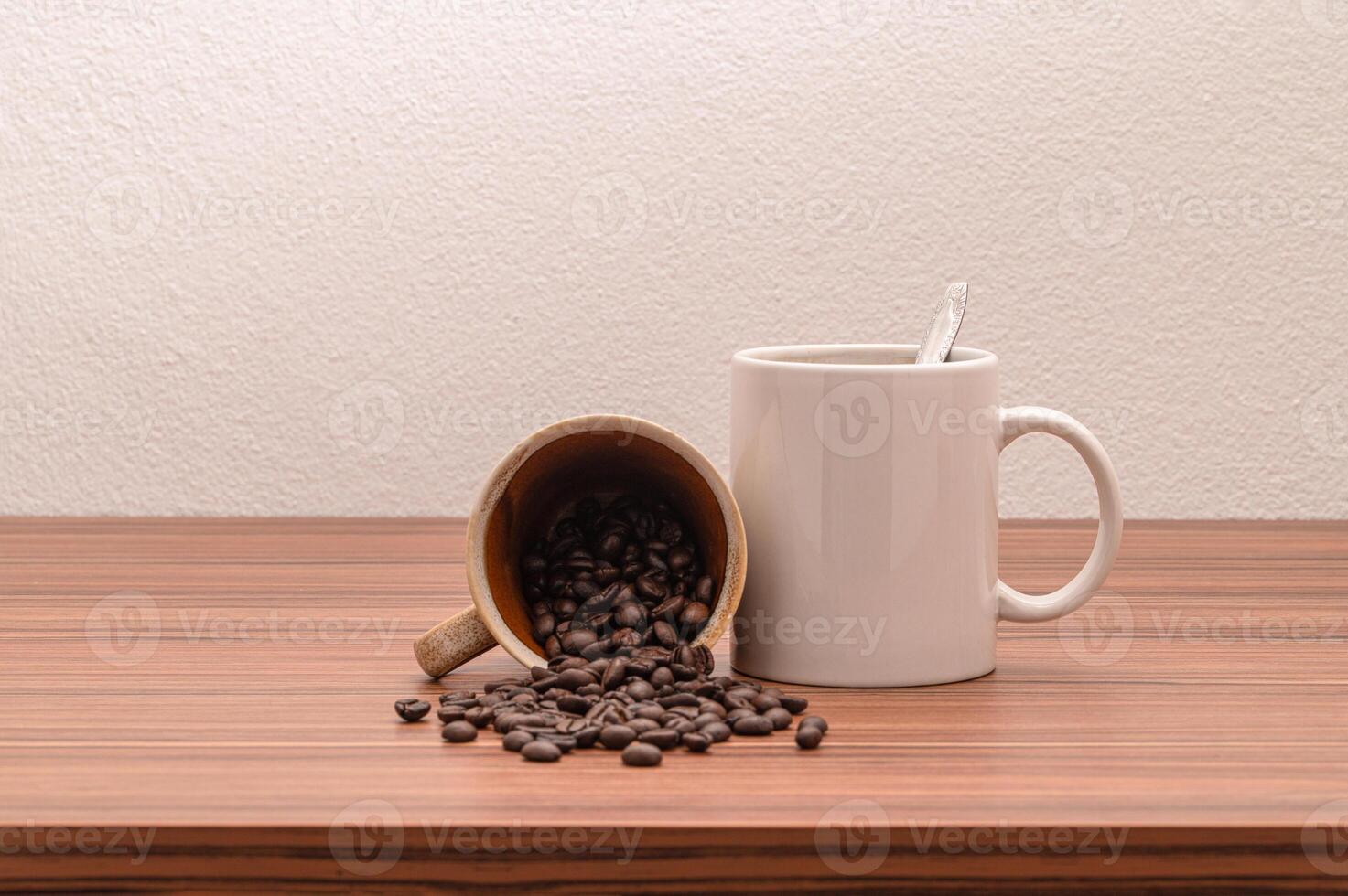 Coffee beans and cup on wooden table photo