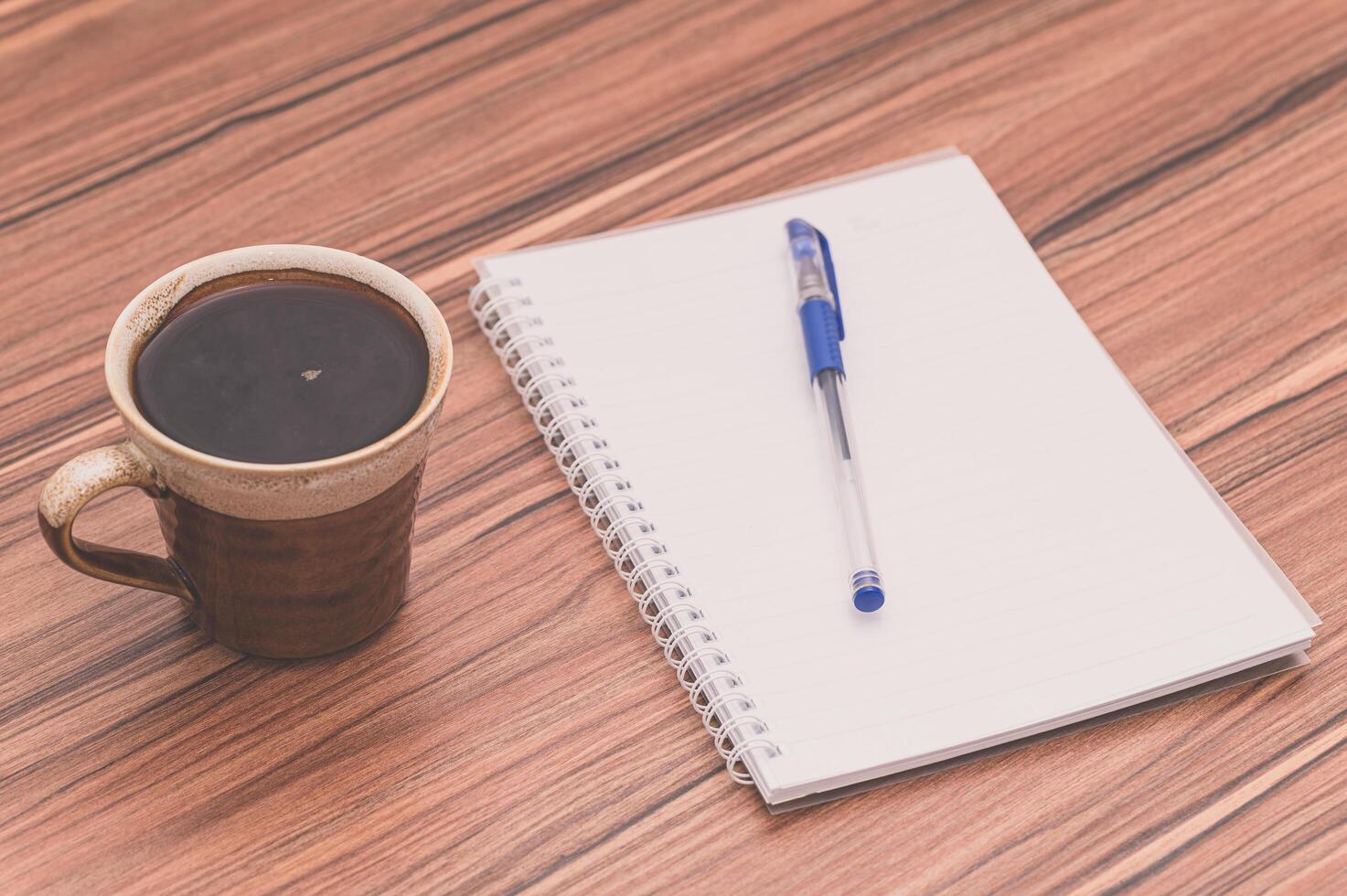 Coffee mug and notebook on the table photo