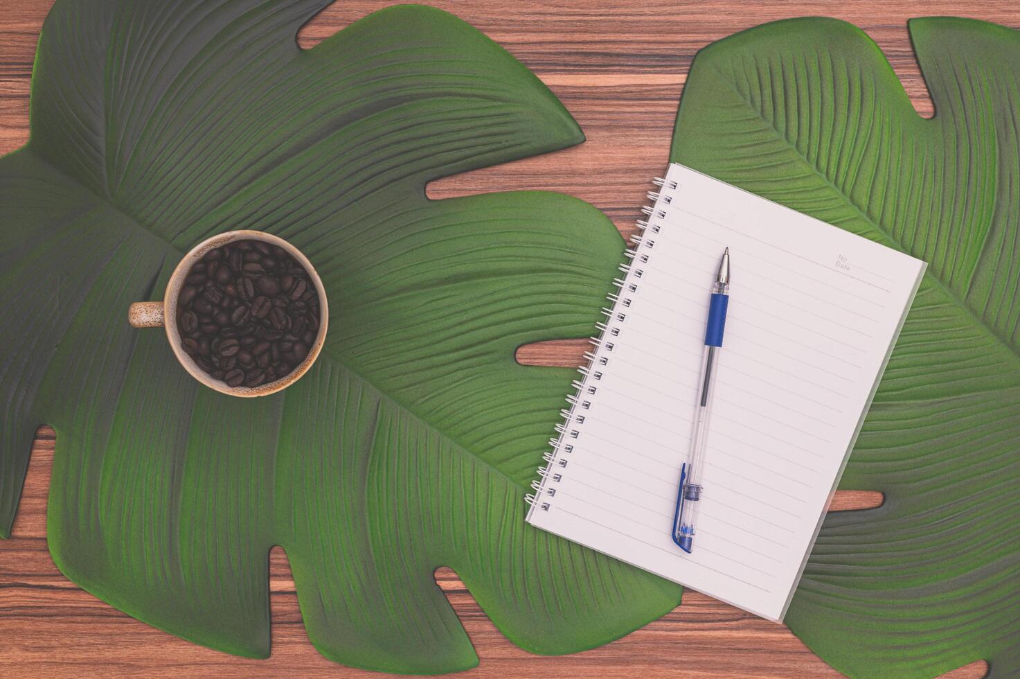 cuaderno y taza de café en el escritorio foto