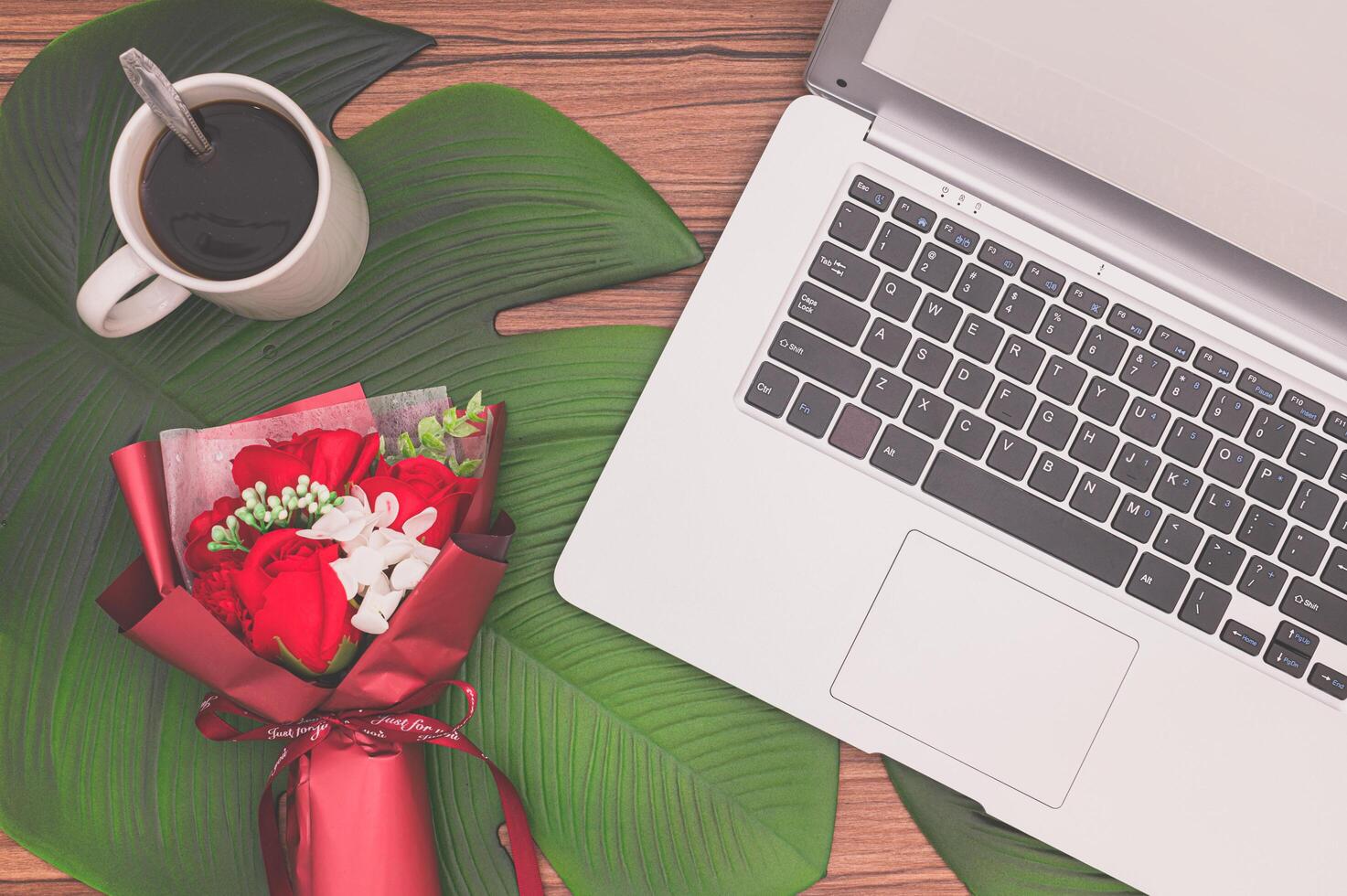 Notebook computer and flower bouquet photo